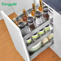 Open kitchen drawer with various items including bottles and containers on a wooden floor.