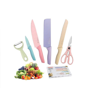 A set of beige colored kitchen knives including a cleaver, chef knife, bread knife, paring knife, peeler, and scissors, displayed with a small pile of vegetables to the side.