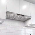 A stainless steel Gorenje range hood mounted under white kitchen cabinets above white subway tiles.