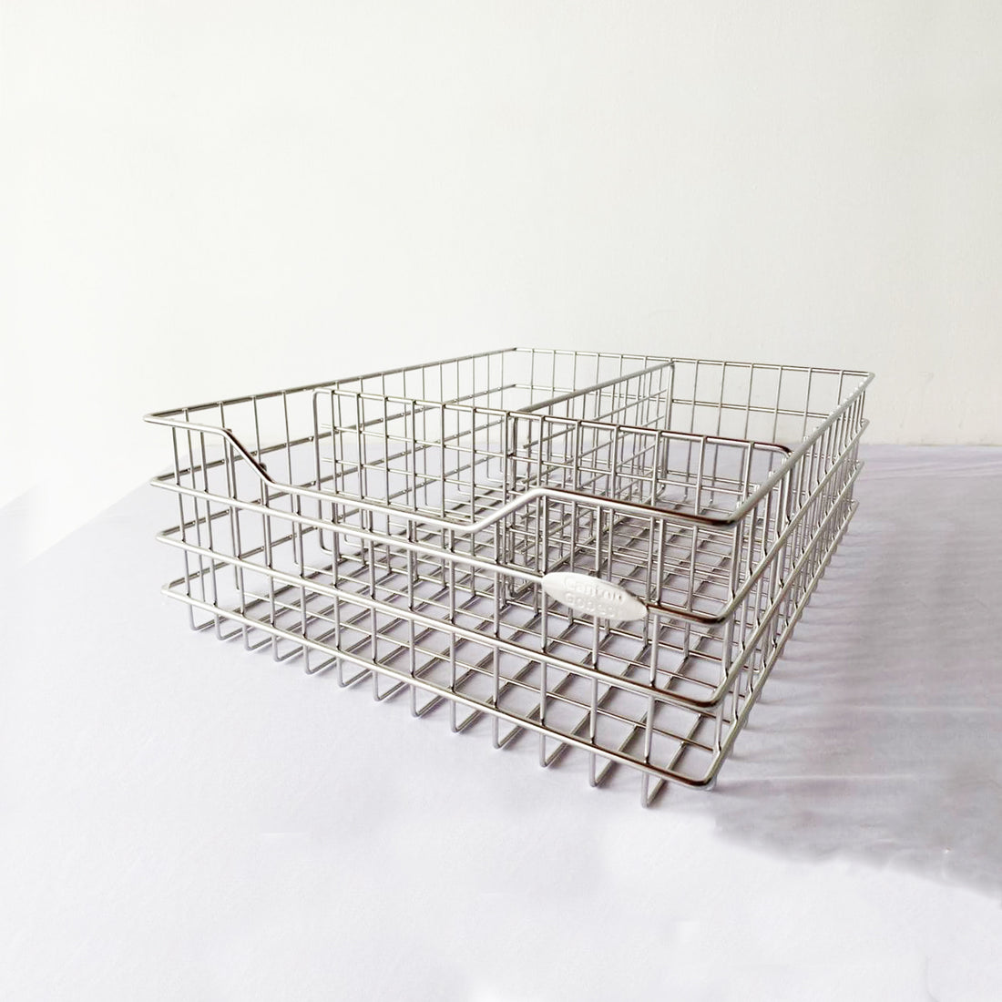 A silver steel wire pull-out basket designed for organizing kitchen utensils.