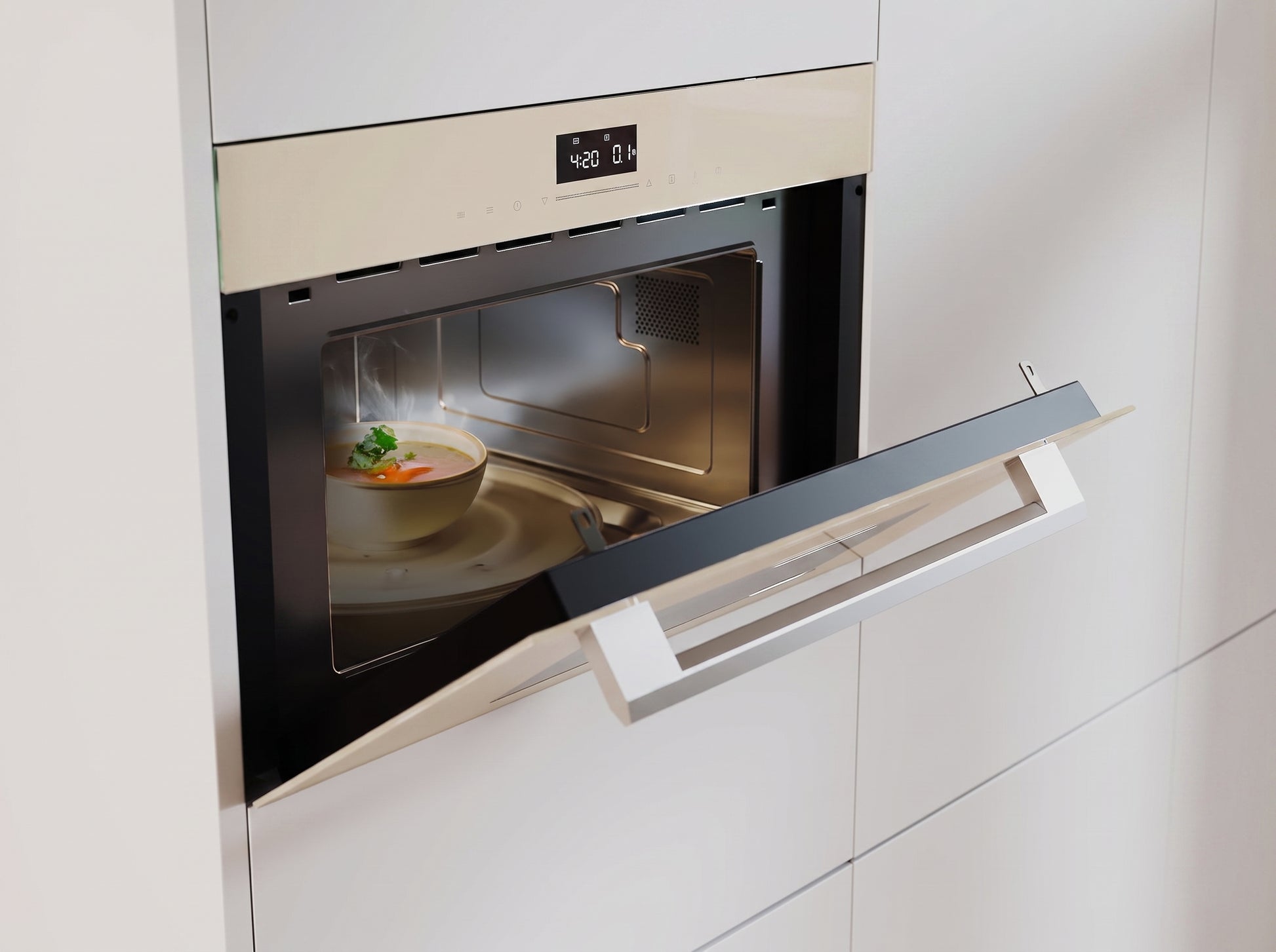 A built-in microwave oven in a modern white kitchen, shown with its door open and a bowl of soup inside on a plate.