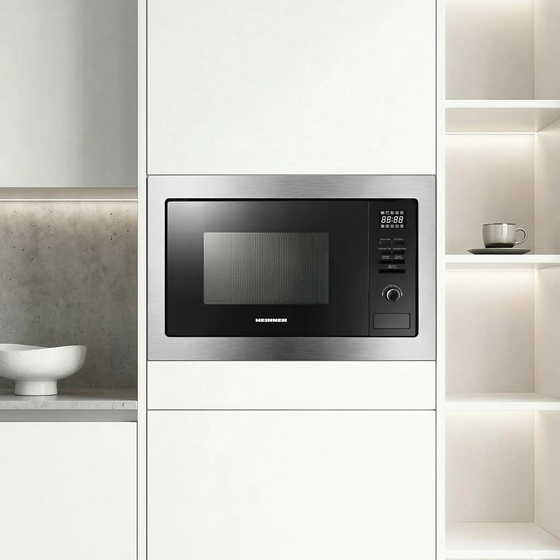 A Heinner built-in microwave oven with a brushed stainless steel frame and a black glass door, featuring a digital display and control buttons on the right side.