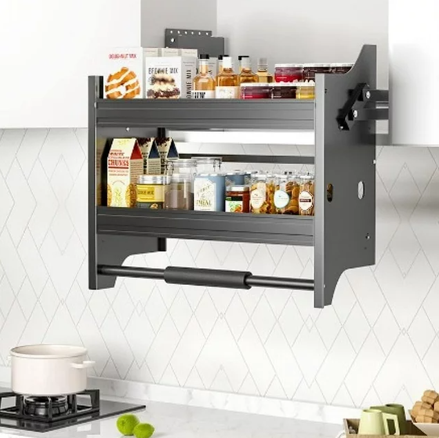 A gray elevator basket with shelves, mounted on a wall in a kitchen setting, filled with various kitchen items.