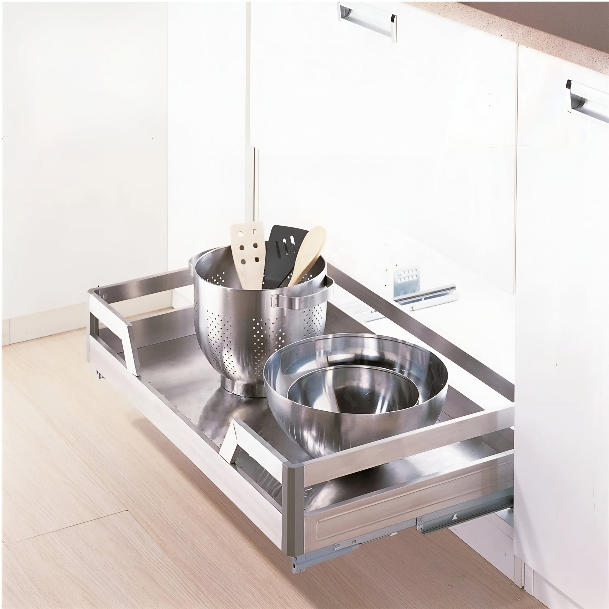 Stainless steel kitchen drawer organizer with utensils in a modern kitchen setting