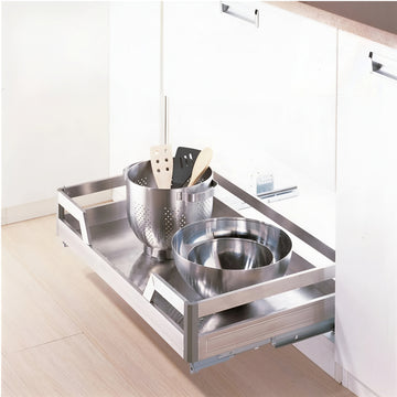Stainless steel kitchen drawer organizer with utensils in a modern kitchen setting