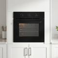 Black oven in a modern kitchen with white cabinets and a plant.