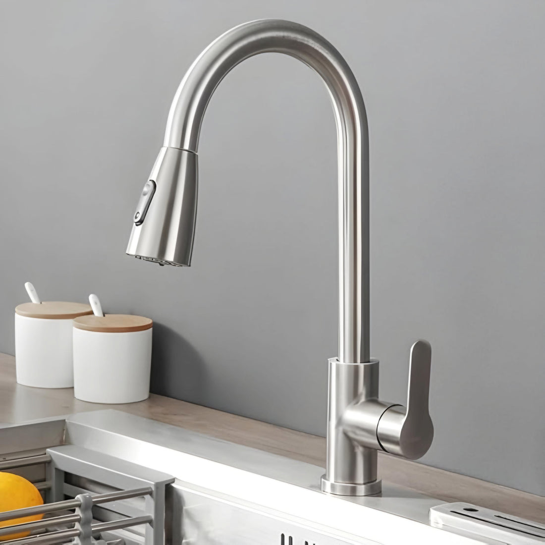 A silver kitchen sink faucet with a pull-out sprayer and a high arch, set against a white background.