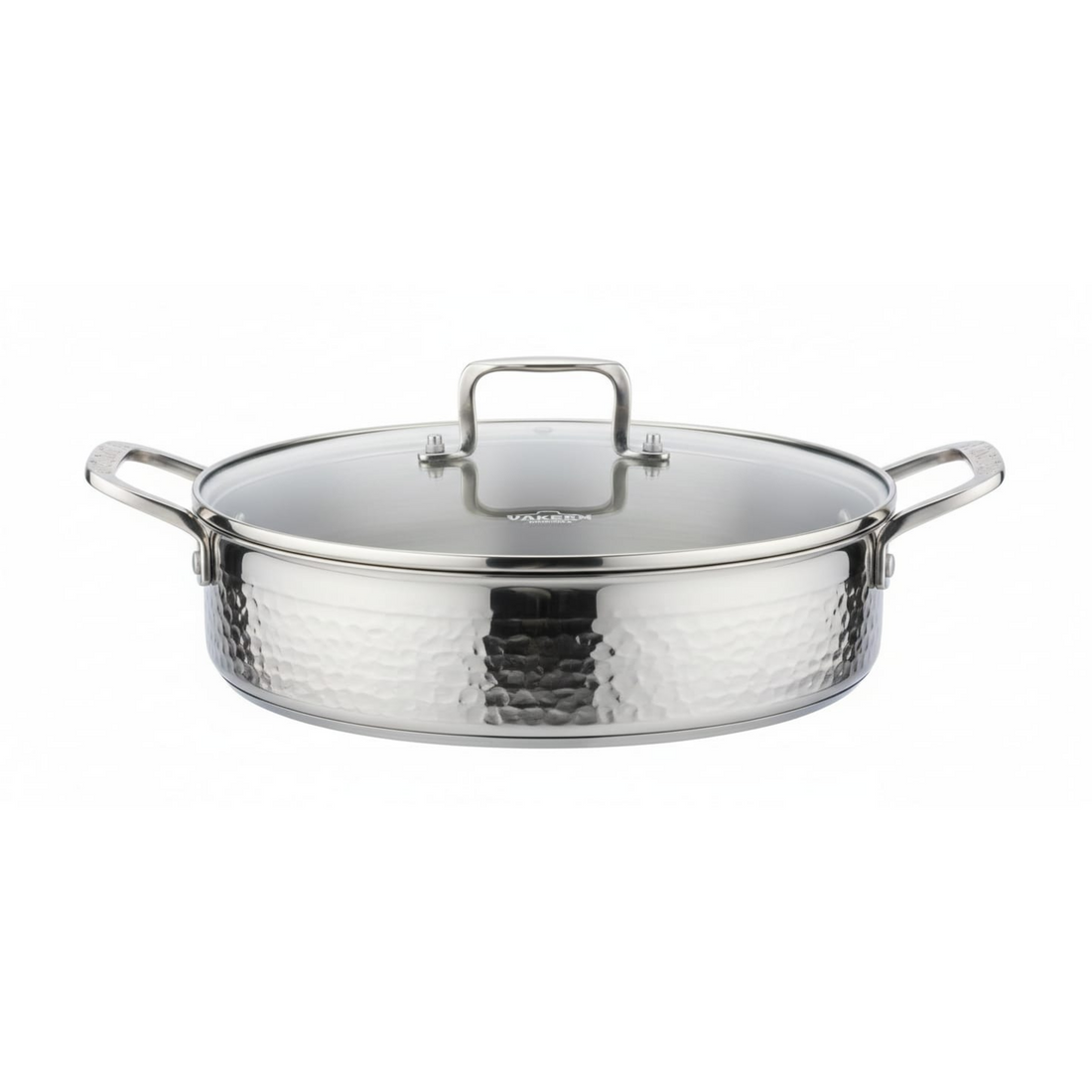 A stainless steel pot with a hammered exterior and a clear glass lid featuring a silver rim and handle, shown on a clean white background. The brand name 'VAKREEN' is visible on the glass lid.